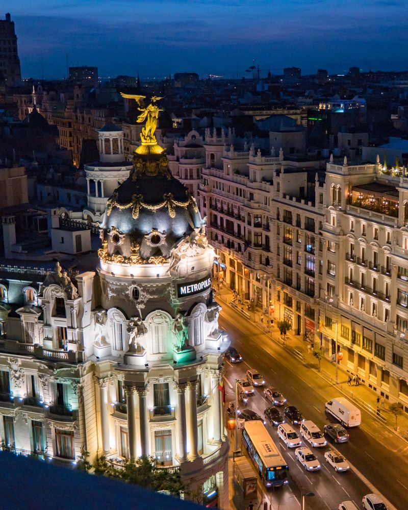 La Gran Vía de Madrid de noche, con el edificio Metrópolis iluminado.
